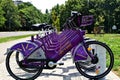 purple electric powered rentable bicycles or e-bikes in wracks in perspective view. eco-friendly lifestyle