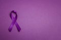 Purple epilepsy awareness ribbon on a purple background with copy space. World epilepsy day