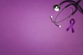 Purple epilepsy awareness ribbon with stethoscope and copy space on a purple background. World epilepsy day