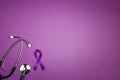 Purple epilepsy awareness ribbon with stethoscope and copy space on a purple background
