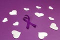 Purple epilepsy awareness ribbon wit white heats on a purple background. World epilepsy day