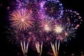 Purple fireworks lighting up the night sky. Bright violet firecrackers explode on black background, holiday celebration event Royalty Free Stock Photo