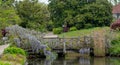 Purple flowered wisteria climbing over a bridge at RHS Wisley, flagship garden of the Royal Horticultural Society, Surrey, UK Royalty Free Stock Photo