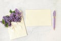 purple flowers in a beautiful envelope with a bow and empty card with purple pen. Flat lay with spring blossom. spring Royalty Free Stock Photo