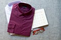 Purple folded mens cotton shirt, red glasses and notebook year plan