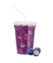 Purple fresh blueberry juice glass and slices half. Fruit juice in clear plastic transparent cup flat lid, ice and straw tube Royalty Free Stock Photo