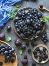 Purple fruits and berries. Blackberries, grapes, plums and figs in a wooden tray and metal plates on dark background. Tasty and ri Royalty Free Stock Photo