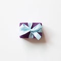 Purple gift box with blue ribbon isolated on white background Royalty Free Stock Photo