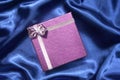 Purple gift box on blue silk