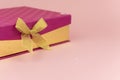 Purple gift box with gold ribbon bow on pink background. milimalism. Sales, shopping, christmas winter and birthday