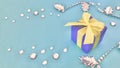A purple gift box on pastel blue background with gemstone and silver leaves decorations. Royalty Free Stock Photo