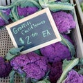 Purple graffiti cauliflower in a bin with chalkboard price Royalty Free Stock Photo