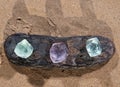 Purple and Green Fluorite Natural Octahedron Crystals on the beach