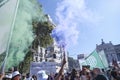 Purple and green smoke flares in the air during the 8M women strike