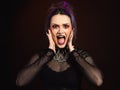 Purple hair goth woman screaming, halloween makeup and crazy expression dark background Royalty Free Stock Photo
