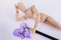 Purple hand drawn heart word love inside jointed manikin doll daydreaming