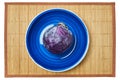 Purple head of red cabbage on a blue plate on a cane serving mat