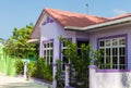 Purple house with white wooden windows under a red roof against a blue sky Royalty Free Stock Photo