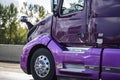 Purple industrial bonnet big rig semi truck tractor running on the highway road at sunny day Royalty Free Stock Photo