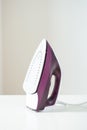 Purple iron on white ironing board