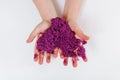 Purple kinetic sand. Child sculpts and plays with sand. Close-up view. White background