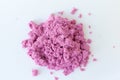 Purple kinetic sand in hand isolated on a white background. Colored sand for modeling for children