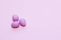 Purple lavender chocolate easter candy eggs on paper background.