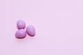 Purple lavender chocolate easter candy eggs on paper background. Royalty Free Stock Photo