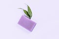 Purple lavender natural soap with green leaves on a purple background. Handmade work