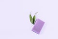 Purple lavender natural soap with green leaves on a purple background. Handmade work