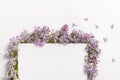 Purple lilac flower frame and empty sheet of paper template on white background with copy space for text. Top view minimal Royalty Free Stock Photo