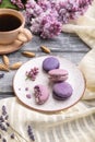 Purple macarons or macaroons cakes with cup of coffee on a gray wooden background. Side view Royalty Free Stock Photo