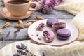 Purple macarons or macaroons cakes with cup of coffee on a gray wooden background. Side view Royalty Free Stock Photo