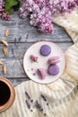 Purple macarons or macaroons cakes with cup of coffee on a gray wooden background. Top view, close up Royalty Free Stock Photo