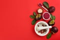 Purple mangosteen powder and fruits on red, flat lay. Space for text