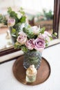 Purple, mauve color fresh summer roses in vase and perfume by th