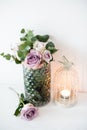 Purple, mauve color fresh summer roses in vase with white wall b