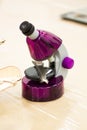 Purple microscope with a bird feather at a children`s science event. Vertical Royalty Free Stock Photo