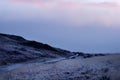 Purple morning dawn view of a mountain bike trail in the Alps. Winding gravel dirt road