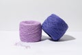 Purple natural knitting threads on gray isolated background with shadow from hard light. The concept of needlework, hobbies and Royalty Free Stock Photo