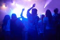 Purple, neon light and people dancing at music festival from back, night and energy at live concert event. Dance, fun Royalty Free Stock Photo