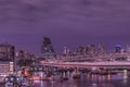 Purple night on circular highway leading to the Rainbow Bridge with Cargo and cruise ships moored or sailing in Odaiba Bay of