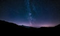 Purple night sky stars. Milky way galaxy across mountains