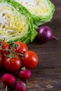 Purple onions, cherry tomatoes and cabbage on dark wooden table. Top views, close-up Royalty Free Stock Photo