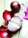 Purple onions and a kitchen knife lie on a lain towel Royalty Free Stock Photo