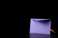 Purple and orange envelopes sideways on black background. Orange envelope is behind the purple
