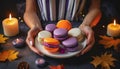 purple orange macaroons on a plate in women\'s hands