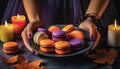 purple orange macaroons on a plate in women\'s hands