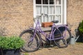 Purple ladies bike against a brick wall