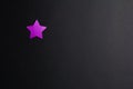 Purple paper star on a black background